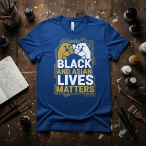 Black and Asian Lives Matters text with gold and white unity fists graphic on a blue t-shirt