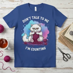 Don't Talk To Me I'm Counting t-shirt featuring a grumpy white cat knitting with yarn